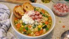 Milde Gemüsesuppe für Kinder: in einem Topf mit Nudeln, Erbsen und Schinken