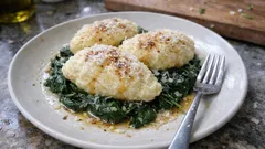 Quark-Nockerl auf Spinat: fluffig gegart, mit brauner Butter und Parmesan serviert