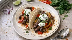 Gefüllte Tortillas mit Limetten-Rind, Paprika-Zwiebel-Gemüse und Koriandercreme