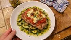 Saftige Koteletts mit Tomate und Mozzarella überbacken – mit Zucchinibett aus dem Ofen