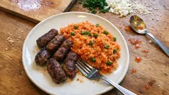 Ćevapčići mit Tomatenreis und Erbsen – unkompliziertes Pfannengericht für jeden Tag