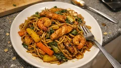 Bami Goreng aus dem Wok: Mie-Nudeln mit Hähnchen, Garnelen und knackigem Gemüse