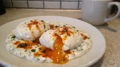 Pochierte Eier auf Joghurt-Kräuter-Sauce – mit warmem Paprikaöl